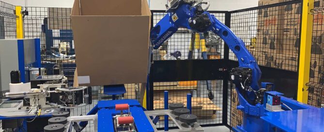 Robotic case erector forming and sealing cardboard boxes on a Pasco Systems Corp automated production line