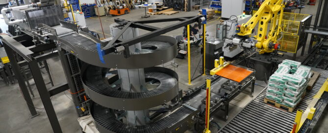 Automated palletizing system with spiral conveyor and robotic arm, showcasing advanced manufacturing automation solutions for efficiency and cost reduction.
