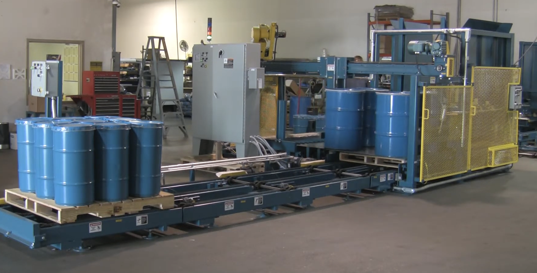PASCO automated robotic drum palletizing and handling system operating on a factory floor.